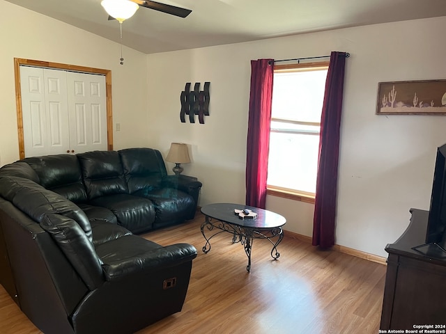 living room featuring ceiling fan, light wood-type flooring, and lofted ceiling