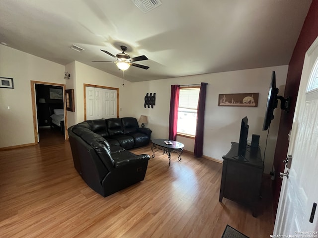 living room with ceiling fan, hardwood / wood-style floors, and vaulted ceiling