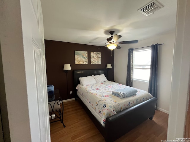 bedroom with ceiling fan and dark hardwood / wood-style floors