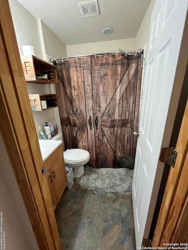 bathroom featuring vanity and toilet