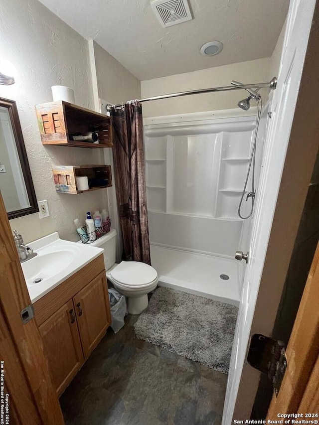 bathroom with a shower with shower curtain, vanity, and toilet