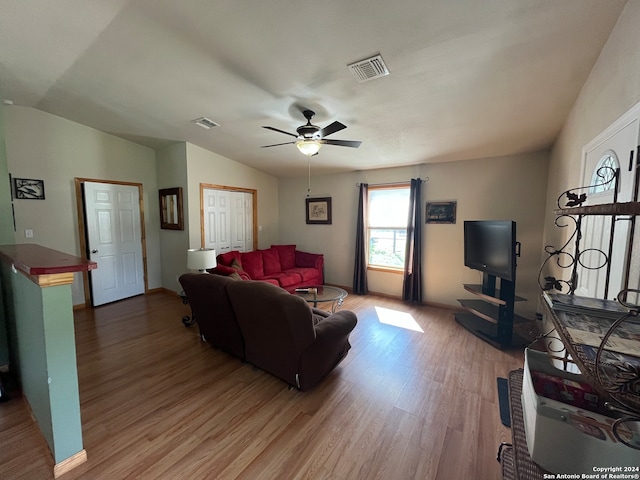 living room with ceiling fan, wood-type flooring, and lofted ceiling