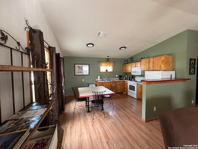 kitchen featuring white appliances, light hardwood / wood-style floors, vaulted ceiling, and sink