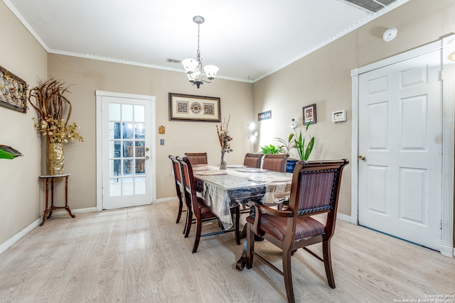 dining room featuring an inviting chandelier, light wood-type flooring, and ornamental molding