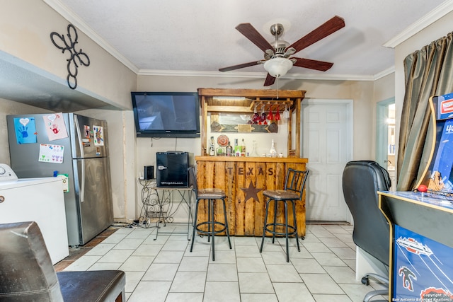 bar featuring ceiling fan, stainless steel fridge, ornamental molding, and washer / dryer