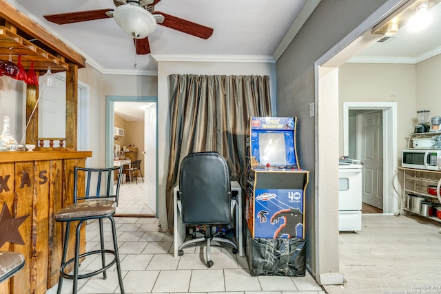 office area featuring ceiling fan, light wood-type flooring, and ornamental molding