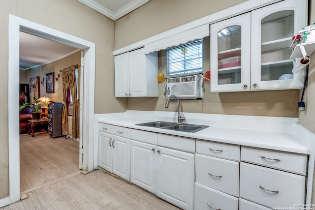 kitchen with cooling unit, crown molding, sink, white cabinets, and light hardwood / wood-style flooring