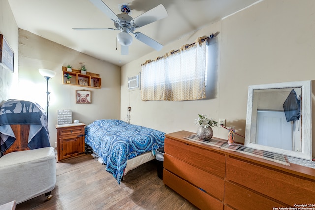 bedroom featuring ceiling fan, light wood-type flooring, and a wall mounted AC