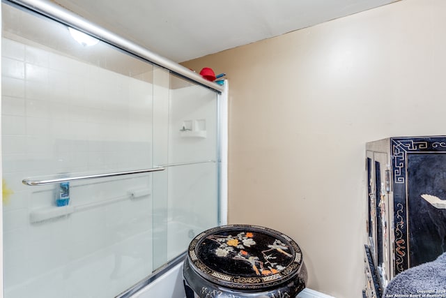 bathroom with combined bath / shower with glass door