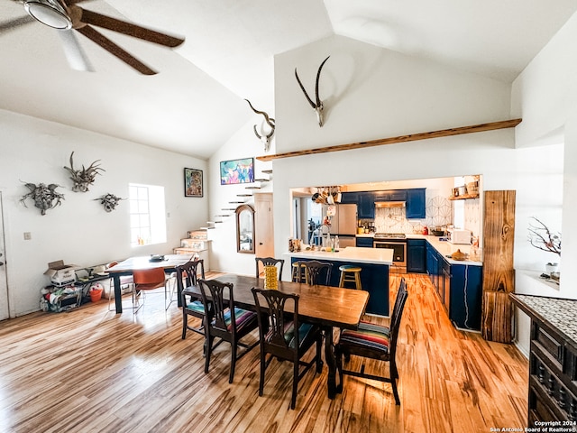 dining space with light hardwood / wood-style floors, ceiling fan, sink, and high vaulted ceiling