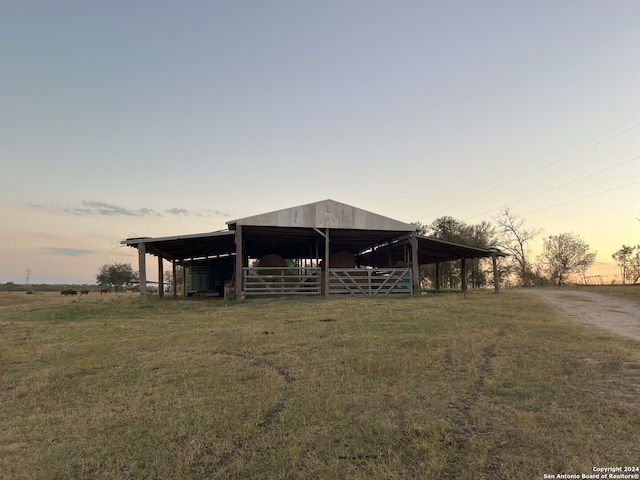 view of front of property with an outbuilding, a rural view, and a lawn