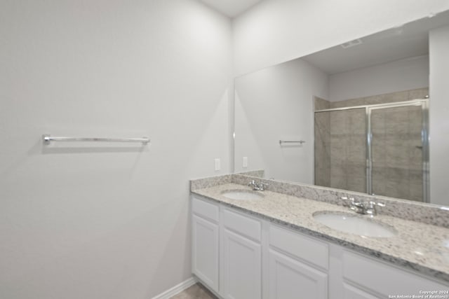 bathroom featuring vanity and a shower with shower door