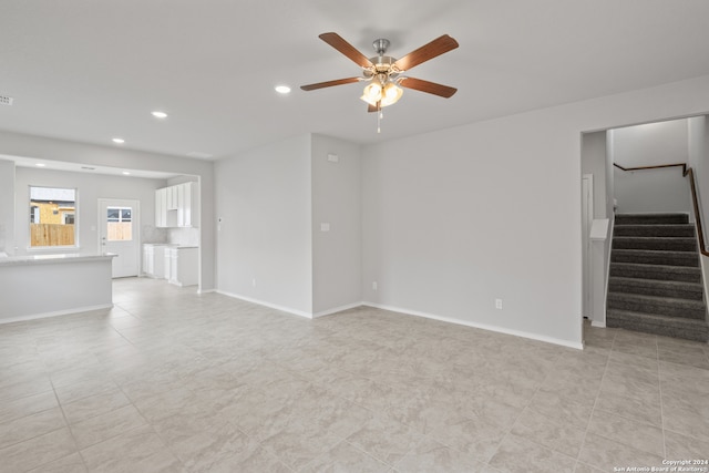 unfurnished living room with light tile patterned floors and ceiling fan