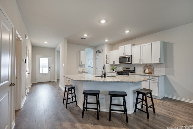 kitchen featuring sink, a center island with sink, white cabinets, and stainless steel appliances