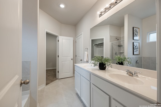 bathroom with vanity, a tile shower, and tile patterned flooring