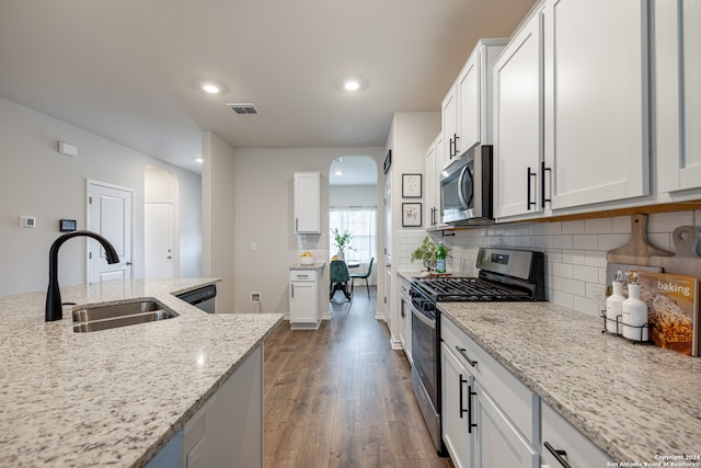 kitchen featuring sink, white cabinets, light stone countertops, and stainless steel appliances