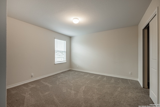 unfurnished bedroom featuring dark colored carpet and a closet