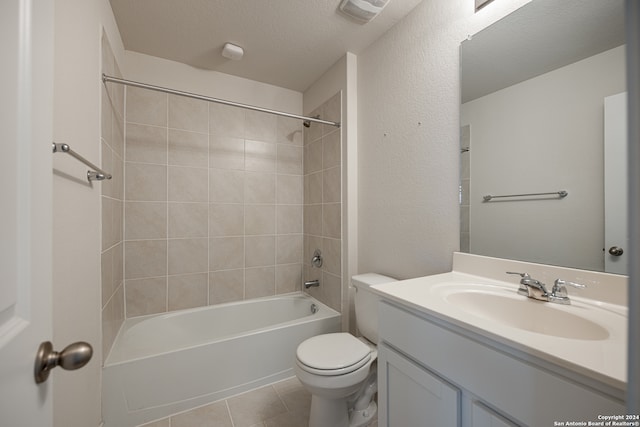 full bathroom with toilet, a textured ceiling, tile patterned floors, vanity, and tiled shower / bath