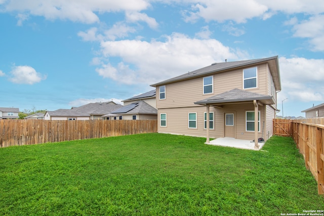 back of property featuring a lawn and a patio