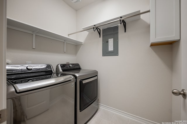 laundry area featuring light tile patterned flooring, electric panel, cabinets, and washing machine and dryer