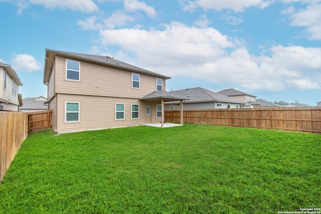 rear view of house with a yard and a patio