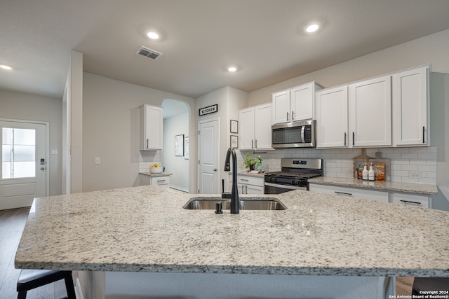 kitchen with sink, white cabinetry, a breakfast bar, and appliances with stainless steel finishes