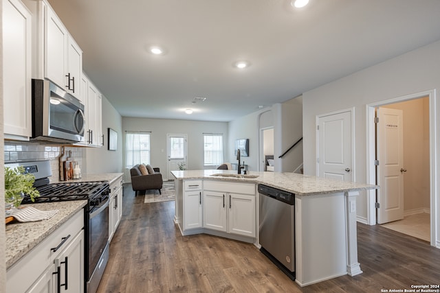 kitchen featuring dark hardwood / wood-style flooring, sink, white cabinetry, tasteful backsplash, and stainless steel appliances