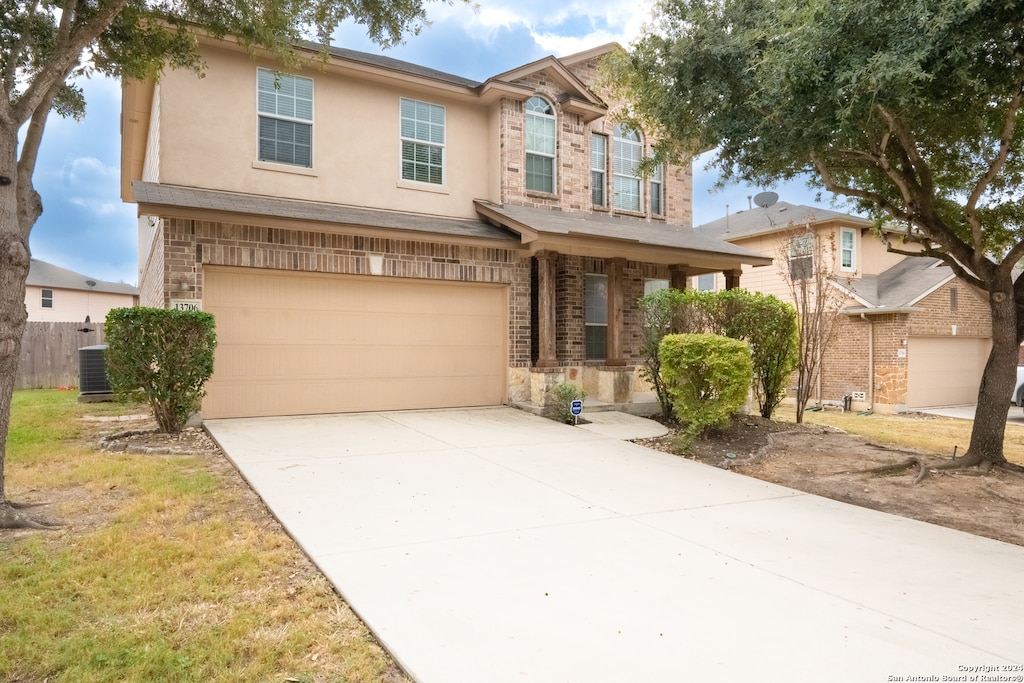 view of front of property featuring a garage and central AC