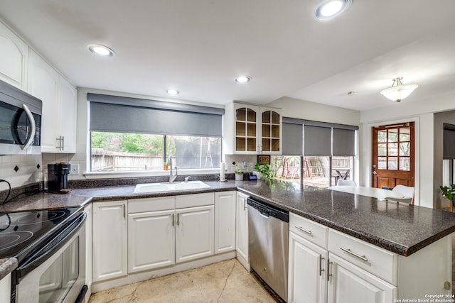 kitchen featuring stainless steel appliances, white cabinets, decorative backsplash, and kitchen peninsula