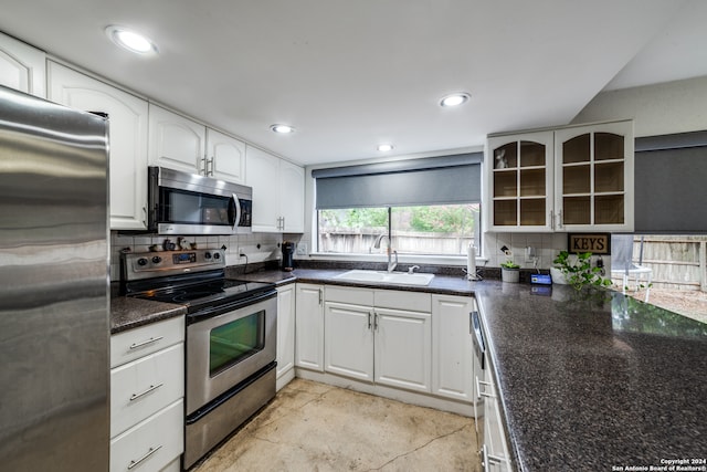 kitchen featuring tasteful backsplash, appliances with stainless steel finishes, sink, and white cabinets