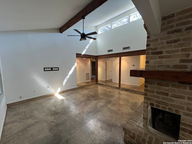 unfurnished living room with concrete floors, high vaulted ceiling, a brick fireplace, beamed ceiling, and ceiling fan