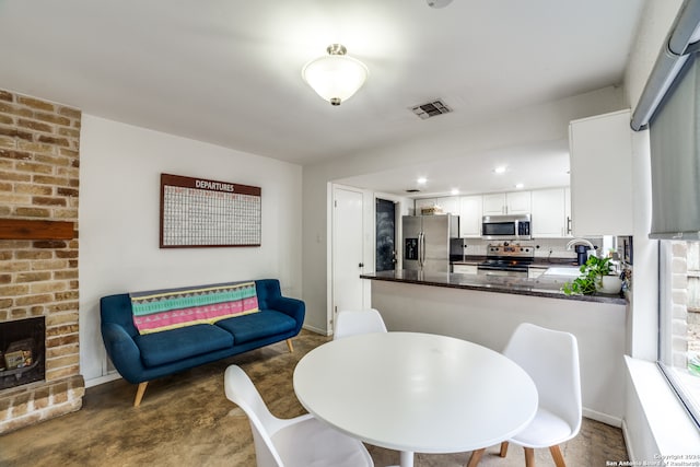 dining area with a brick fireplace and sink