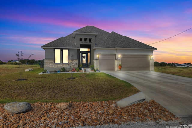 prairie-style home with a garage and a lawn