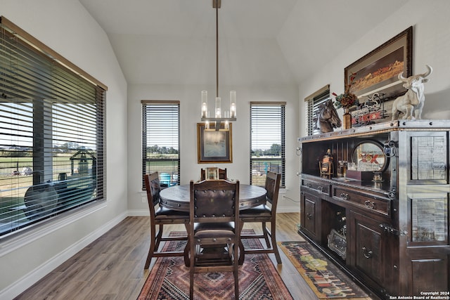 dining space featuring a chandelier, lofted ceiling, and light hardwood / wood-style floors