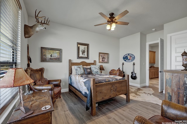 bedroom with hardwood / wood-style floors, ensuite bath, and ceiling fan