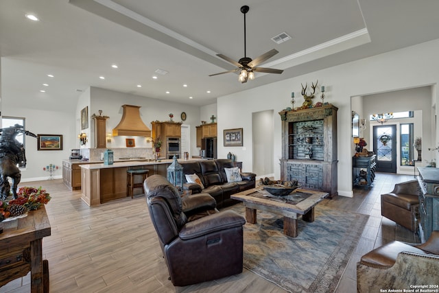 living room with light hardwood / wood-style floors, a healthy amount of sunlight, crown molding, and ceiling fan