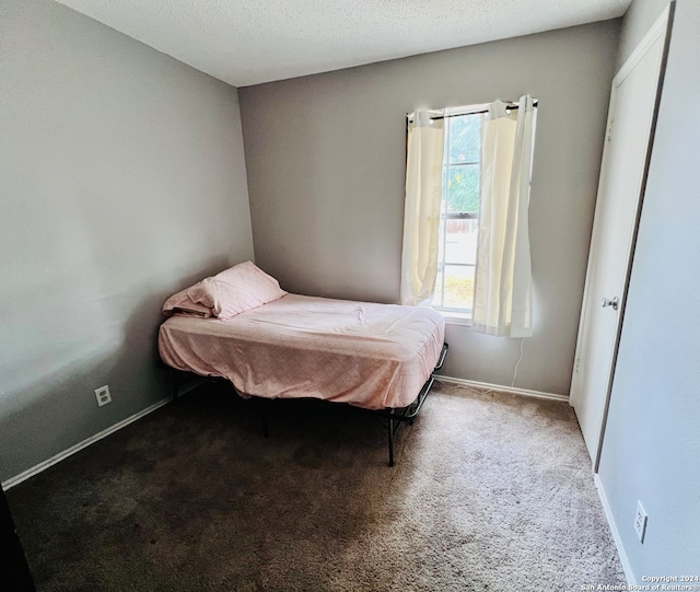 carpeted bedroom featuring a textured ceiling