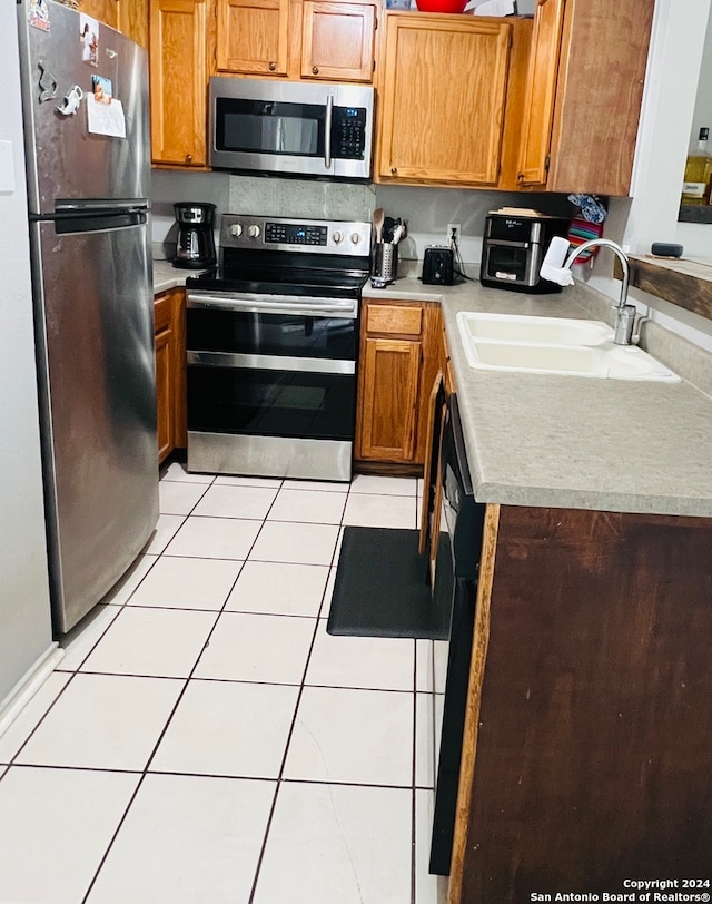 kitchen featuring light tile patterned flooring, sink, and appliances with stainless steel finishes