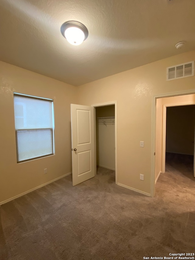 unfurnished bedroom with a closet, carpet, and a textured ceiling