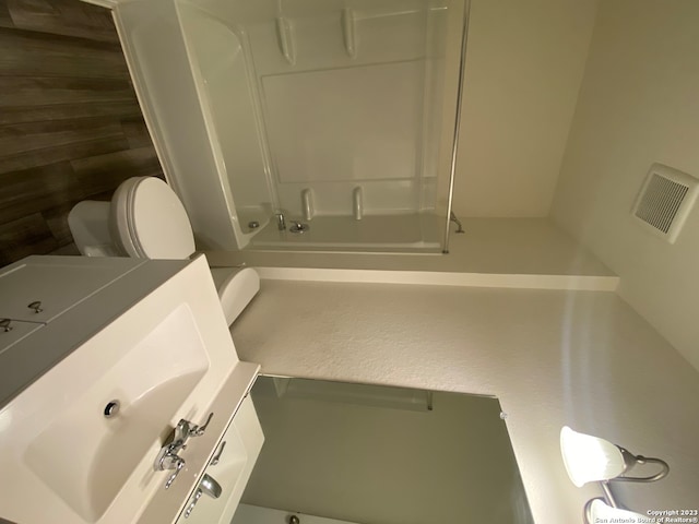 bathroom with sink, toilet, and a shower