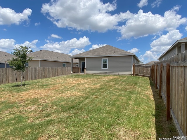 rear view of property with a yard