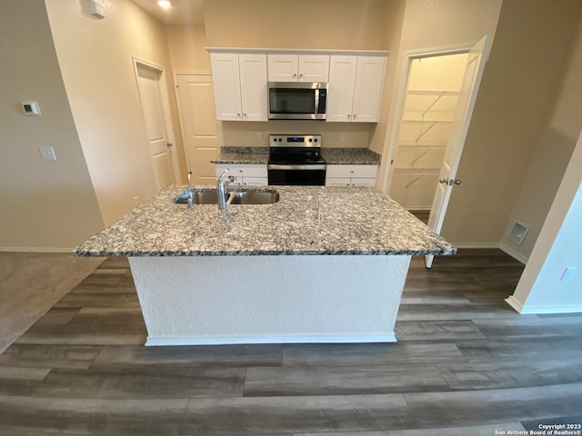 kitchen featuring light stone counters, appliances with stainless steel finishes, sink, white cabinets, and a kitchen island with sink