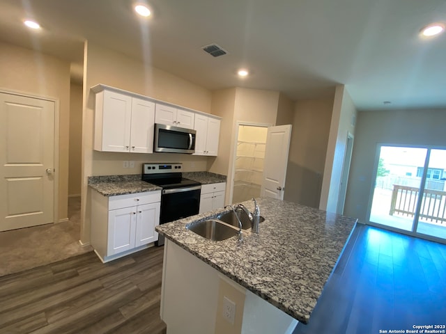 kitchen with stainless steel appliances, white cabinetry, sink, and an island with sink