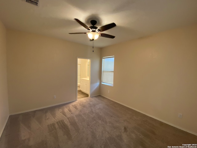 unfurnished bedroom featuring ensuite bathroom, ceiling fan, and carpet