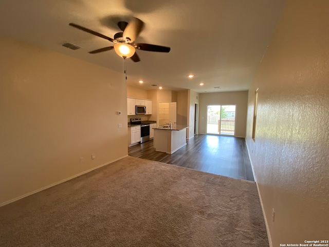 unfurnished living room featuring dark wood-type flooring, sink, and ceiling fan