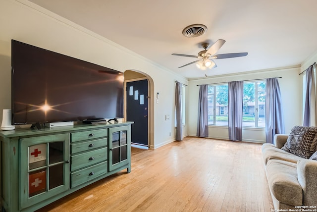 living room with ceiling fan, light wood-type flooring, and ornamental molding