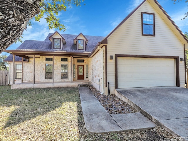 view of front facade with a garage, a front yard, and covered porch