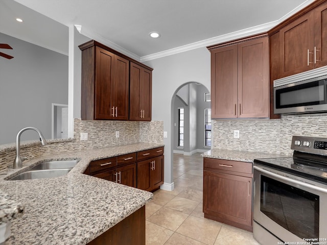 kitchen featuring ornamental molding, stainless steel appliances, light tile patterned floors, light stone countertops, and sink