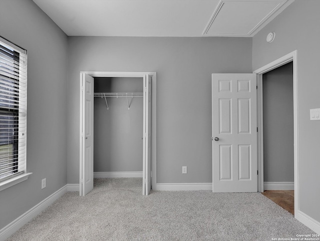 unfurnished bedroom with light colored carpet and a closet