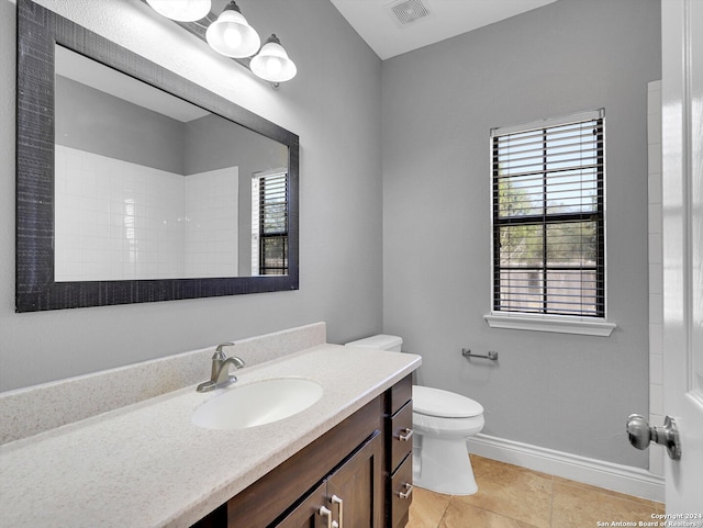 bathroom with toilet, vanity, tile patterned flooring, and walk in shower